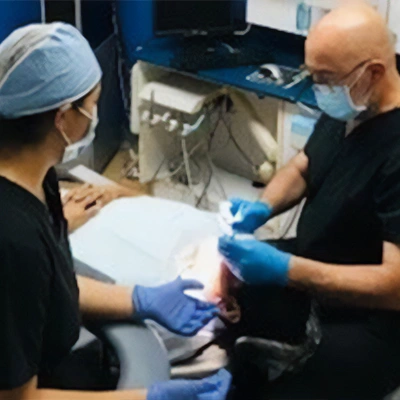 Dentist Juan Carlos Barbosa With Patient Cleaning Their Teeth